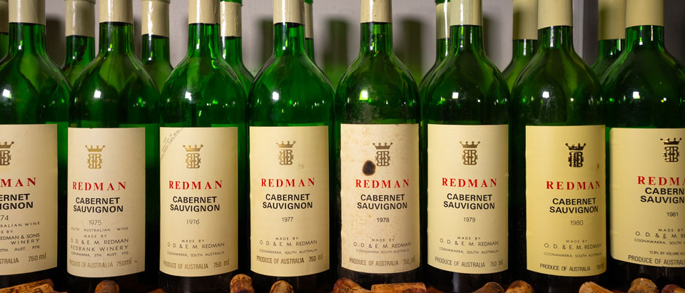 Old bottles of Redman cabernet lined up with their corks